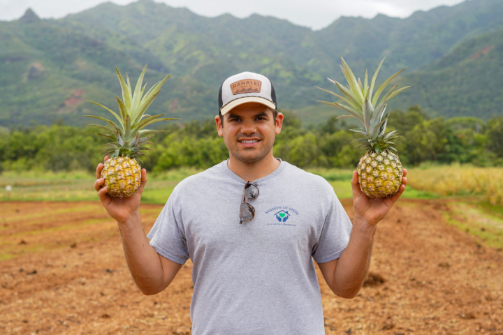a hand holding a kite while standing in front of a mountain