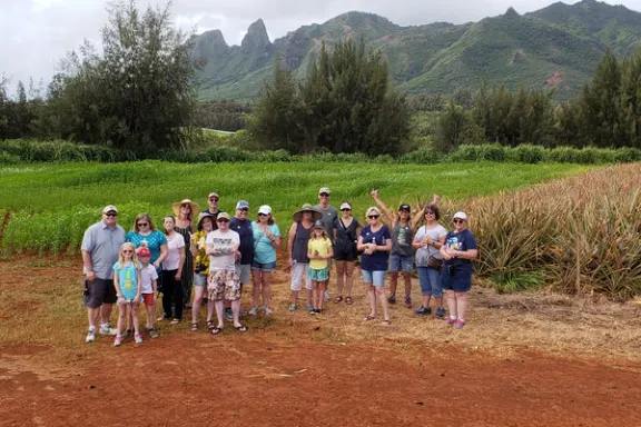 a group of people standing on top of a dirt field